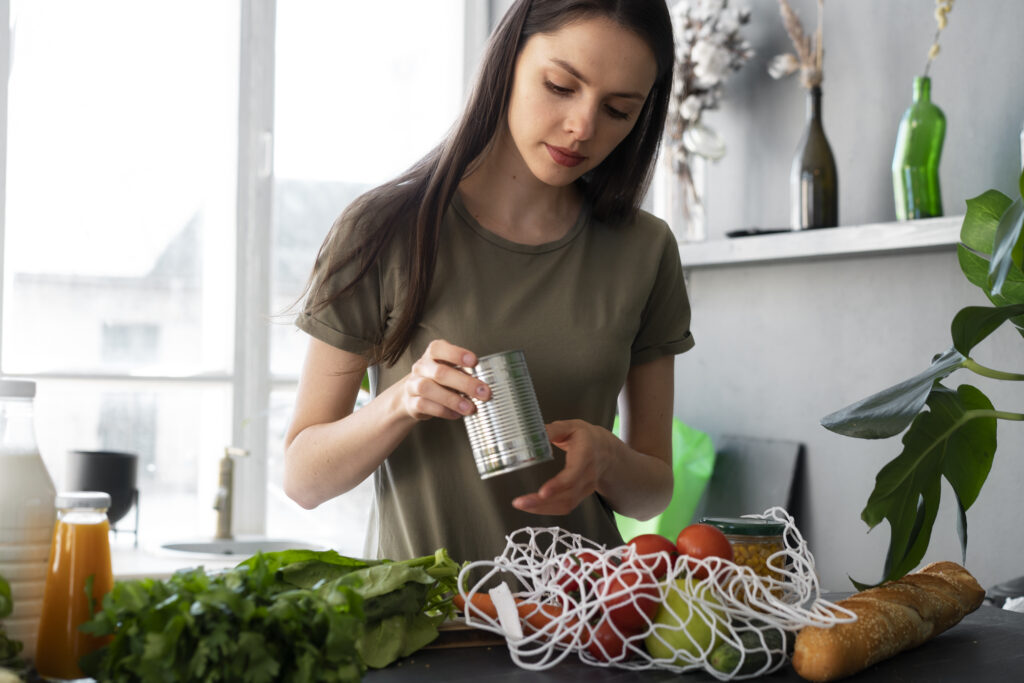 Mulher preparando ingredientes frescos e enlatados para uma refeição sustentável