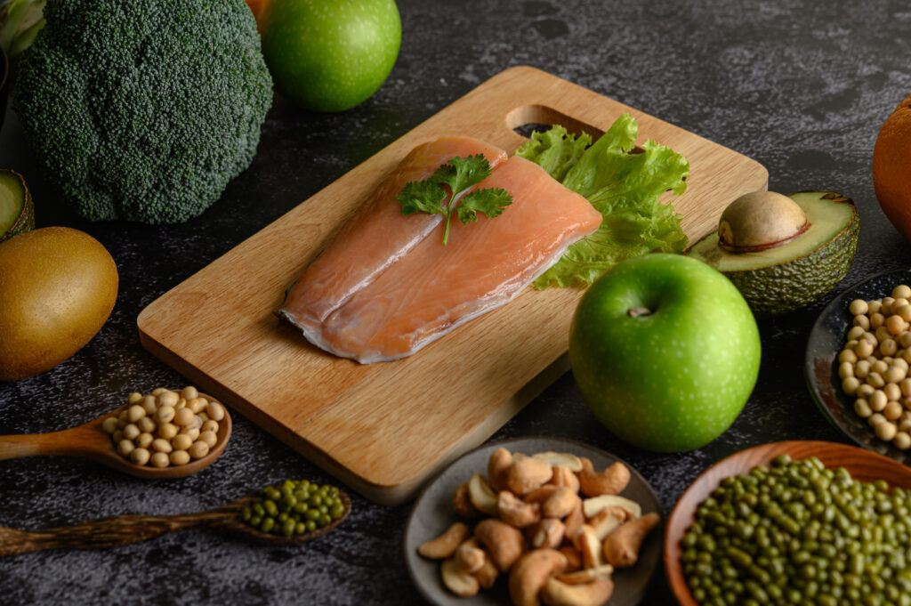 Filé de salmão em tábua com vegetais e castanhas ao redor