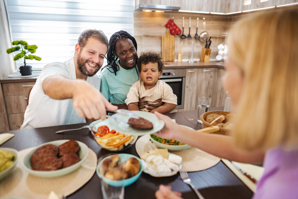 Família reunida à mesa desfrutando de uma refeição juntos em um ambiente aconchegante.