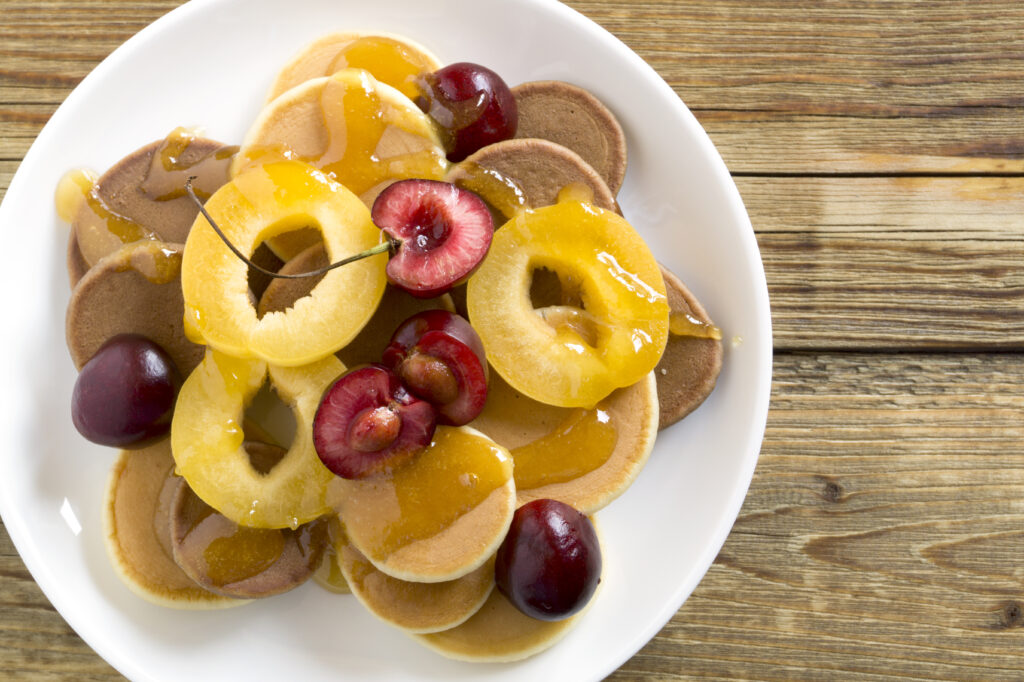 Panquecas de frutas frescas com calda saudável de pêssego e cerejas.